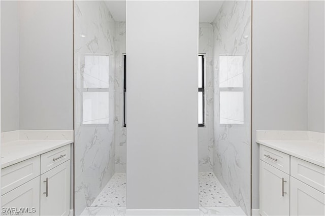 bathroom with vanity and a tile shower