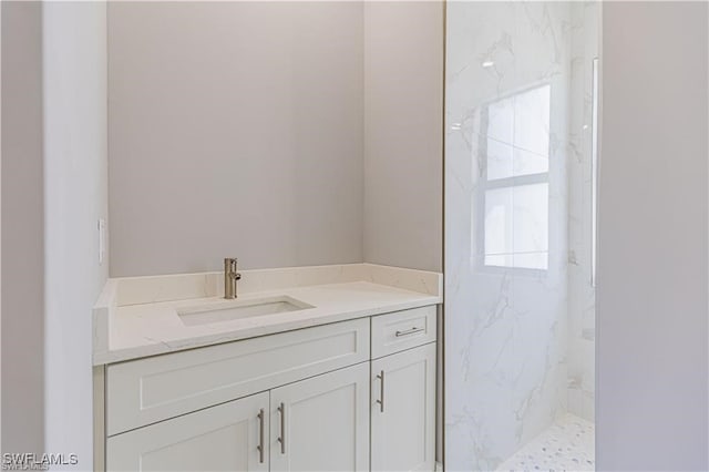 bathroom with vanity and a tile shower