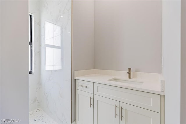 bathroom with vanity and tiled shower