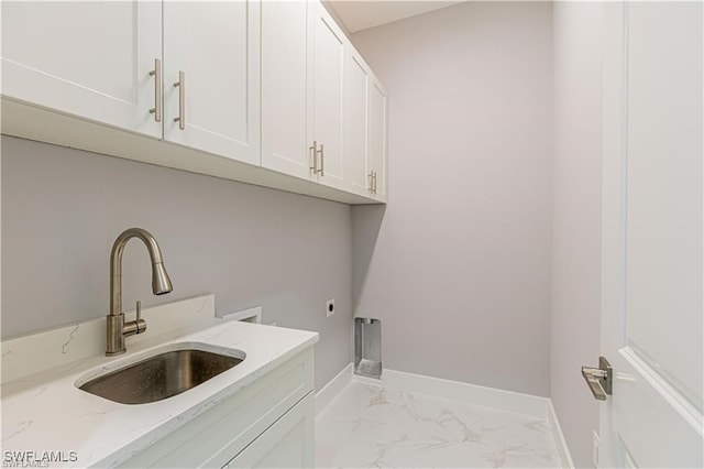 clothes washing area featuring electric dryer hookup, sink, hookup for a washing machine, and cabinets