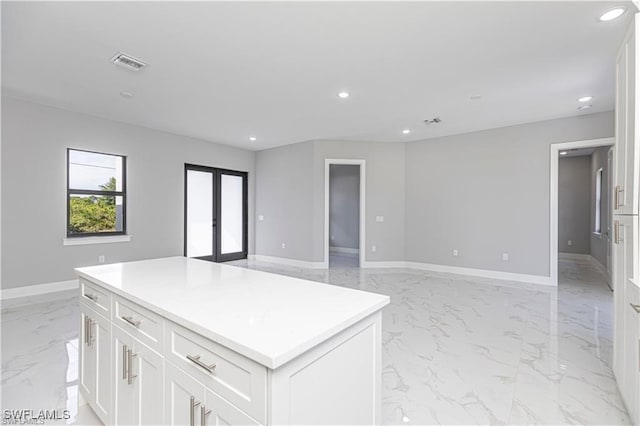 kitchen featuring white cabinetry, a center island, and french doors