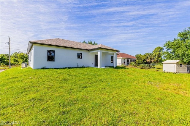 back of property with a yard and a storage unit