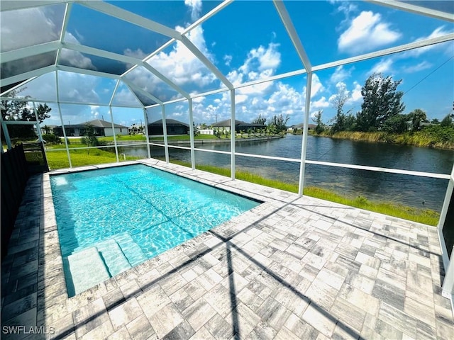 pool with a lanai, a water view, a patio, and a lawn