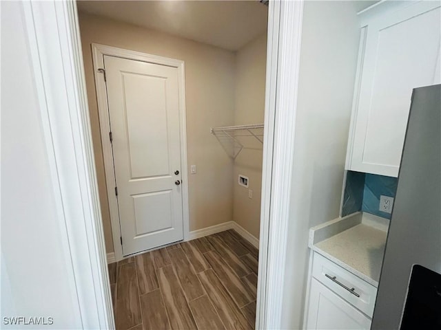 laundry area with wood finish floors, laundry area, and baseboards