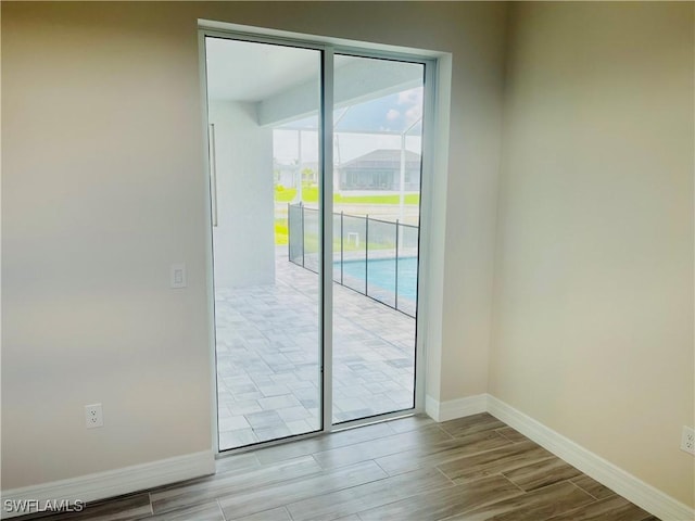 doorway to outside featuring wood tiled floor and baseboards