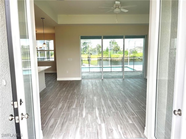 unfurnished sunroom featuring ceiling fan