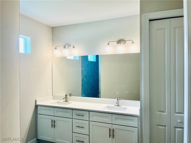 full bathroom featuring a closet, a sink, and double vanity