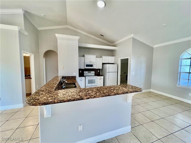 kitchen with sink, white appliances, light tile patterned floors, white cabinetry, and kitchen peninsula