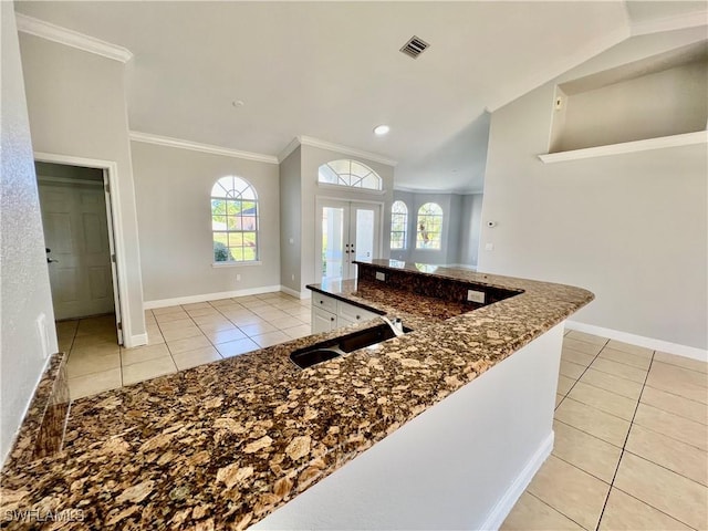 kitchen featuring french doors, crown molding, sink, and light tile patterned floors