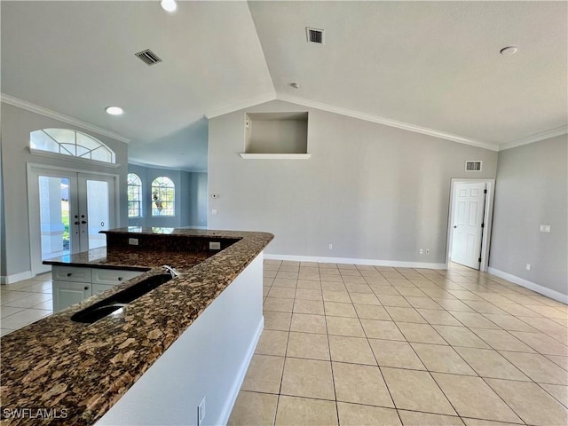 kitchen featuring french doors, sink, crown molding, dark stone countertops, and light tile patterned floors