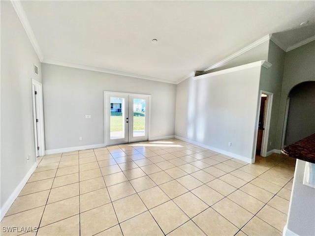 tiled spare room featuring vaulted ceiling, ornamental molding, and french doors