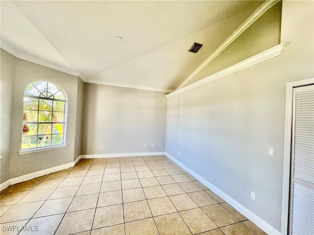 empty room with crown molding, lofted ceiling, and light tile patterned flooring