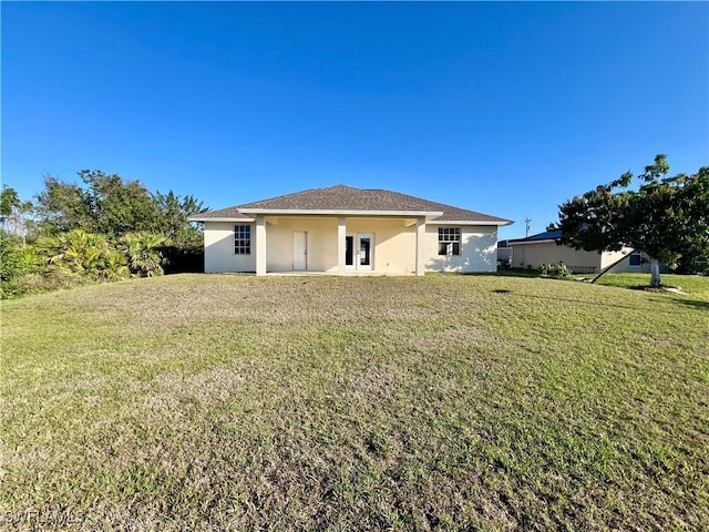 rear view of property with a yard