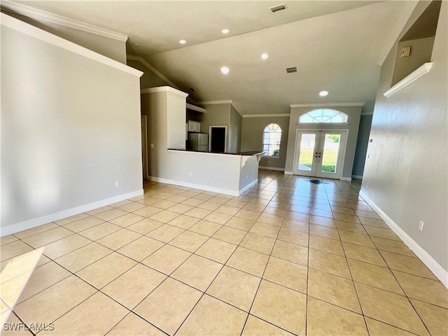 interior space featuring ornamental molding, vaulted ceiling, light tile patterned flooring, and french doors