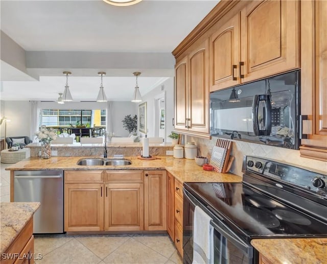 kitchen featuring decorative light fixtures, light stone countertops, sink, and black appliances