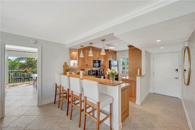 kitchen with stainless steel fridge, a kitchen bar, hanging light fixtures, stove, and kitchen peninsula