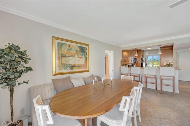 dining space with light tile patterned floors and crown molding