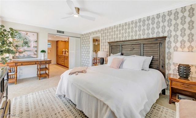 tiled bedroom with ensuite bath, ornamental molding, and ceiling fan