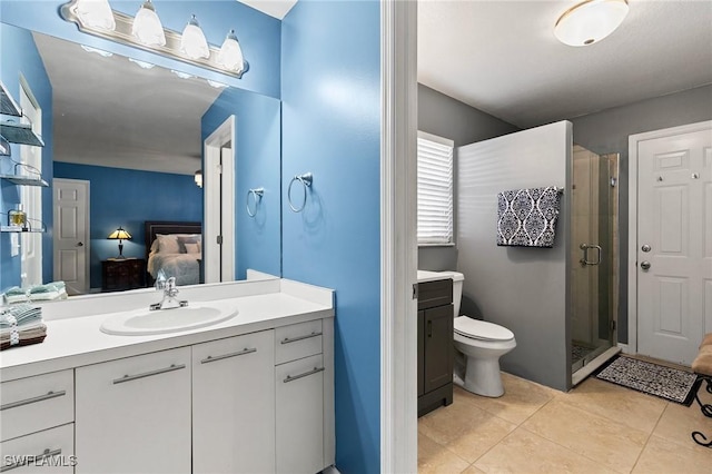 bathroom with an enclosed shower, vanity, tile patterned floors, and toilet