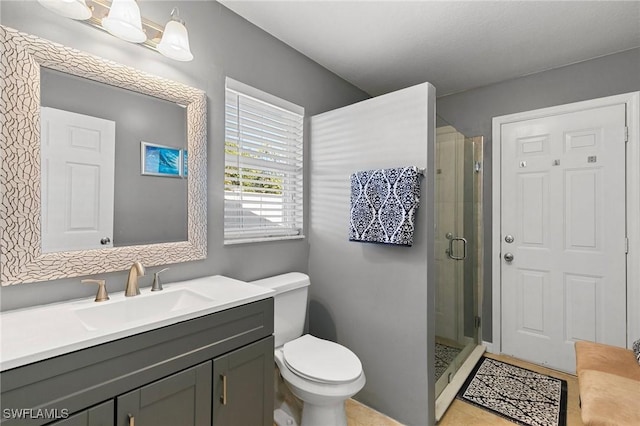 bathroom with vanity, an enclosed shower, and toilet