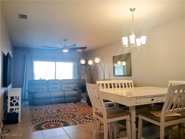 tiled dining room featuring ceiling fan with notable chandelier