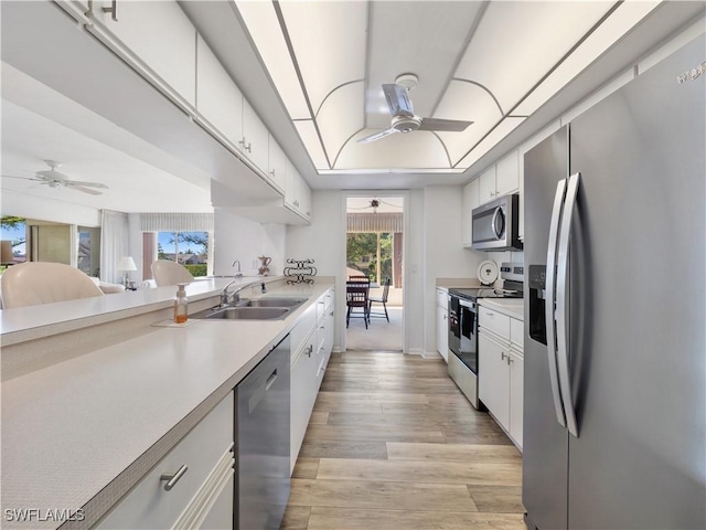 kitchen with appliances with stainless steel finishes, sink, white cabinets, and ceiling fan