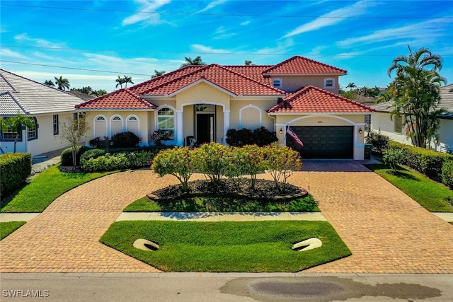 mediterranean / spanish home with a garage and a front yard