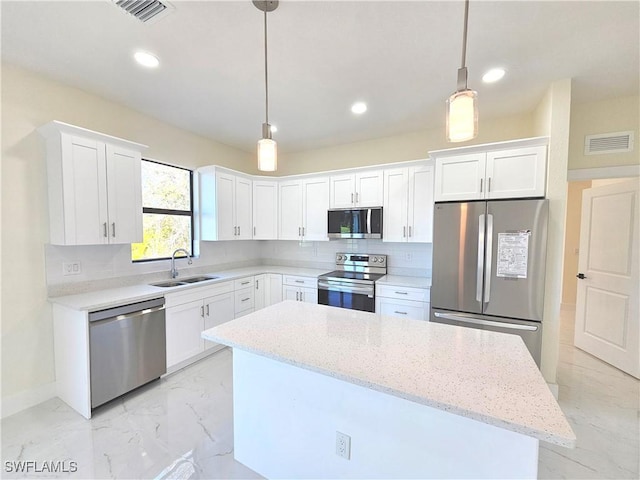 kitchen with stainless steel appliances, decorative light fixtures, sink, and white cabinets