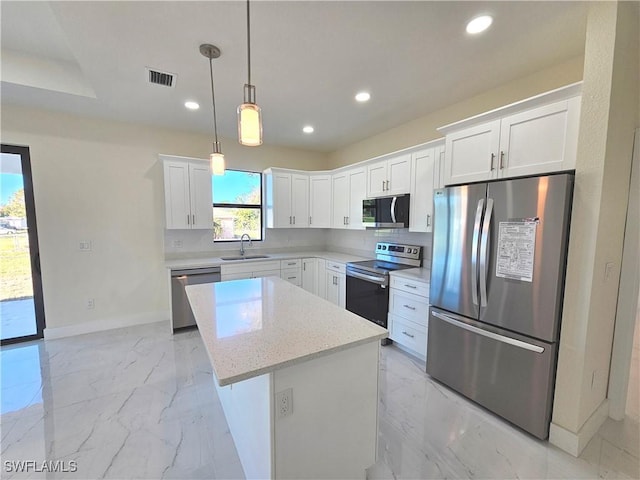 kitchen featuring white cabinetry, sink, a center island, and appliances with stainless steel finishes