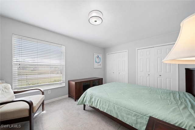 tiled bedroom featuring two closets