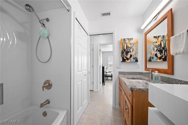 bathroom featuring tiled shower / bath, vanity, and tile patterned floors