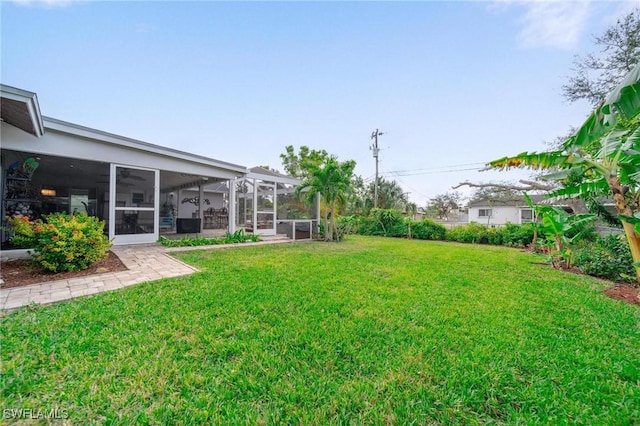 view of yard featuring a sunroom and glass enclosure