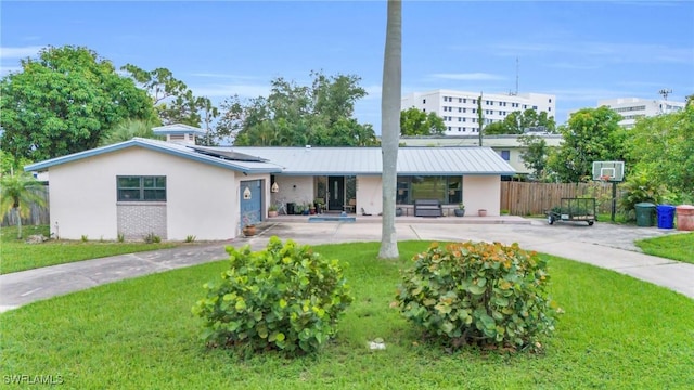 rear view of property featuring a yard and solar panels