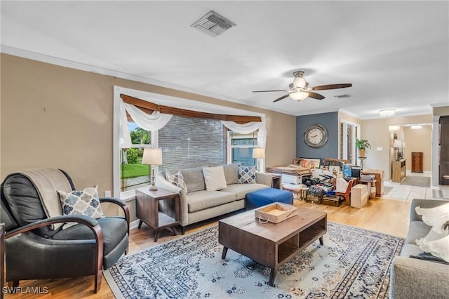 living room featuring light hardwood / wood-style flooring, ceiling fan, and ornamental molding