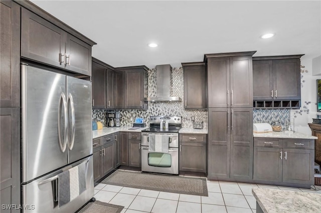 kitchen with backsplash, appliances with stainless steel finishes, wall chimney exhaust hood, light tile patterned flooring, and dark brown cabinets