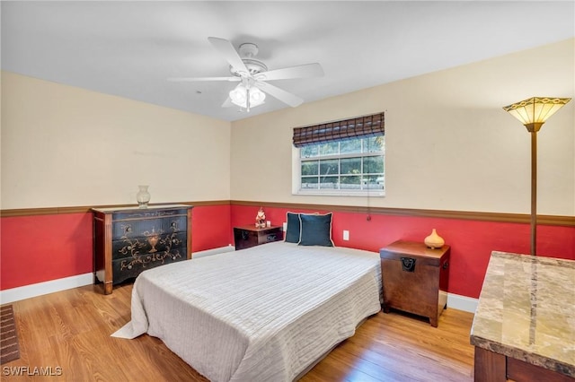 bedroom with light hardwood / wood-style floors and ceiling fan