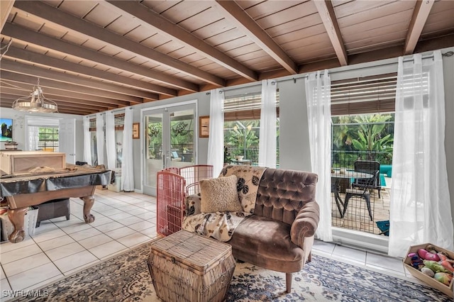 interior space with a healthy amount of sunlight, light tile patterned floors, beamed ceiling, and french doors