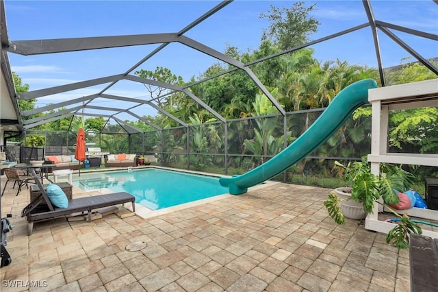 view of swimming pool featuring glass enclosure, a patio area, and a water slide