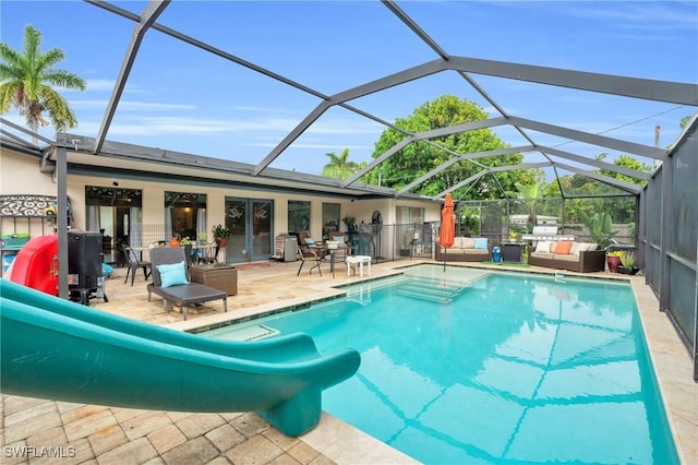 view of swimming pool with an outdoor living space, a patio, and glass enclosure