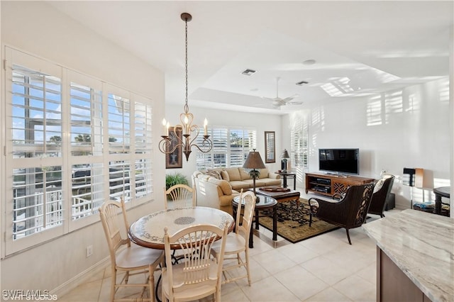 tiled dining area with ceiling fan with notable chandelier