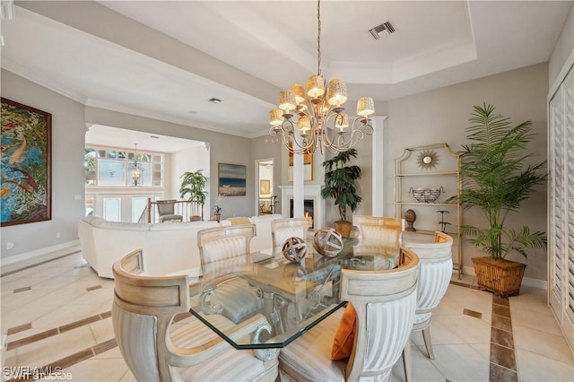 dining room with light tile patterned floors, a notable chandelier, ornamental molding, and a raised ceiling