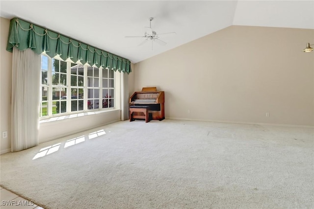 carpeted spare room featuring vaulted ceiling and ceiling fan