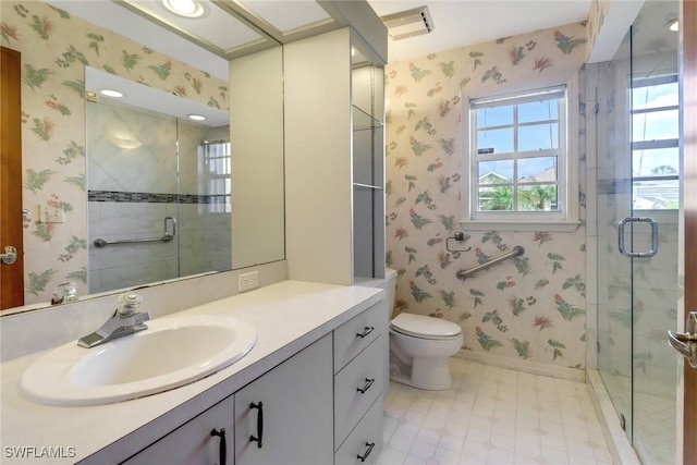 bathroom featuring a shower with door, vanity, and toilet