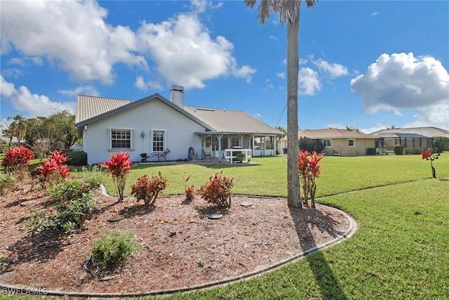 rear view of property featuring a lawn