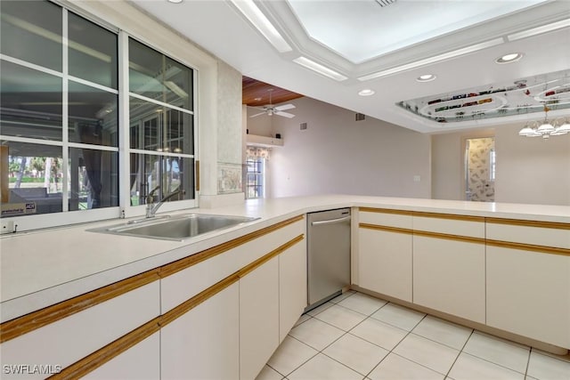 kitchen featuring sink, light tile patterned floors, ceiling fan, white cabinetry, and a raised ceiling