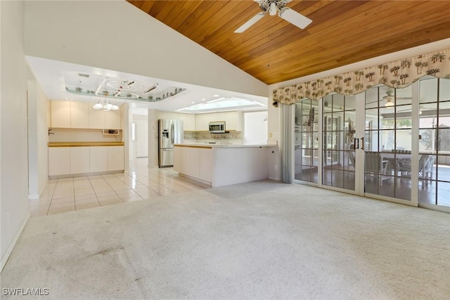 unfurnished living room featuring wood ceiling, vaulted ceiling, light colored carpet, and ceiling fan