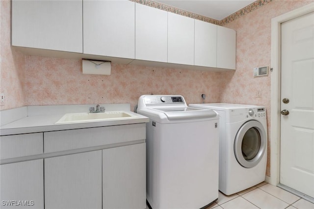 laundry room featuring cabinets, separate washer and dryer, sink, and light tile patterned floors