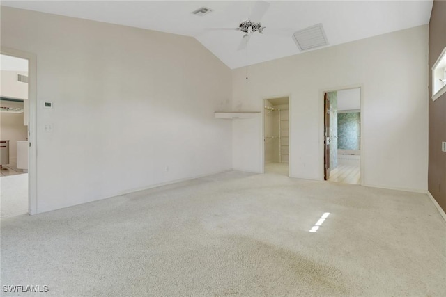 unfurnished bedroom with lofted ceiling, ensuite bathroom, a walk in closet, light colored carpet, and a closet