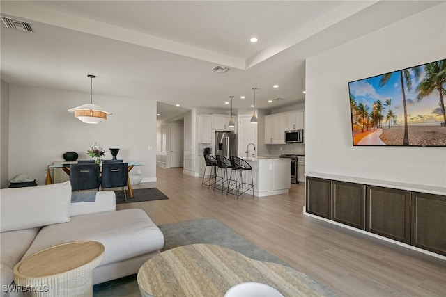 living room with sink and light hardwood / wood-style floors