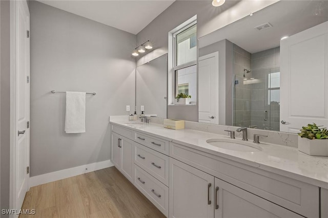 bathroom featuring a shower with door, wood-type flooring, and vanity